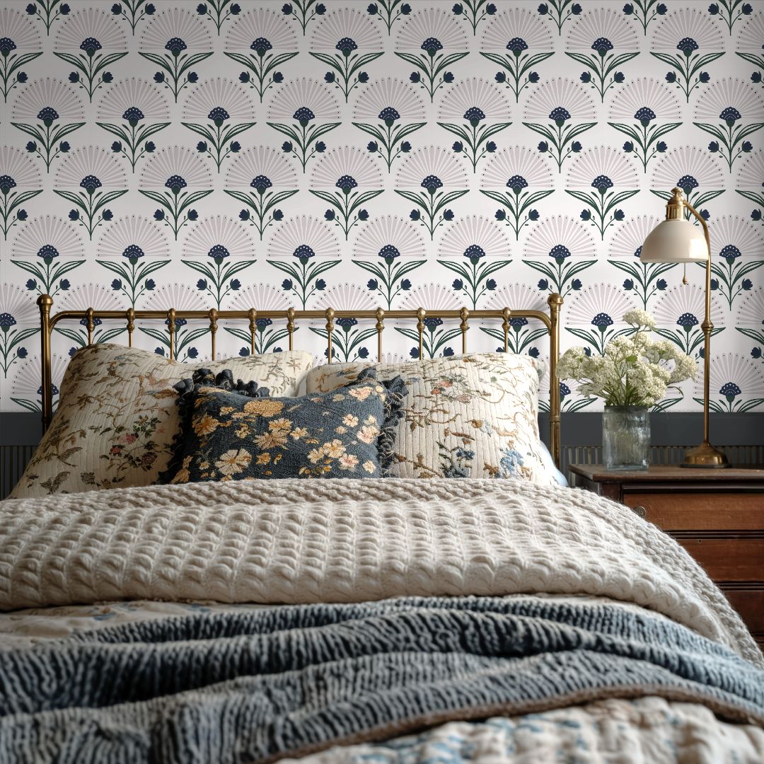 indigo and green floral wallpaper behind brass bed with cream bedding vintage pillows and wood nightstand