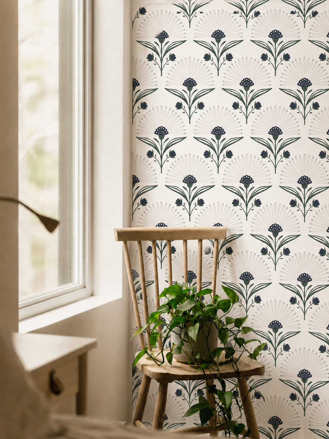 indigo and green art deco floral wallpaper beside window with wood chair and trailing plant
