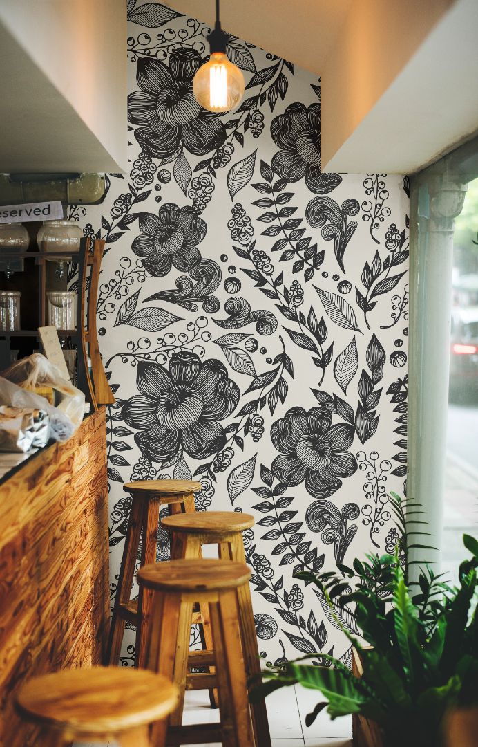Inkwell Botanica black and ivory wallpaper in a cozy café setting with natural wood tones