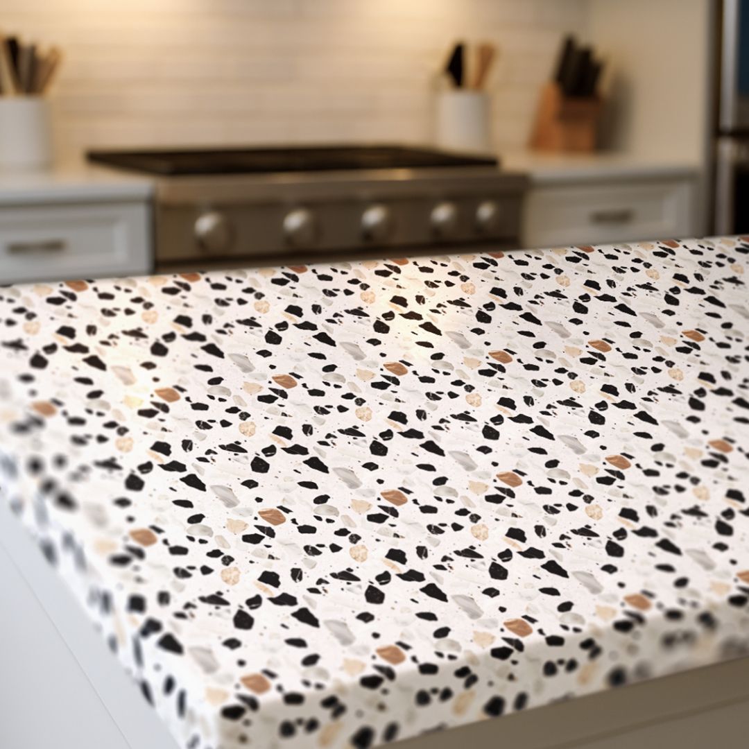 Close up of Ivory Atelier Terrazzo countertop film 106 showing ivory base with charcoal and beige stone flecks