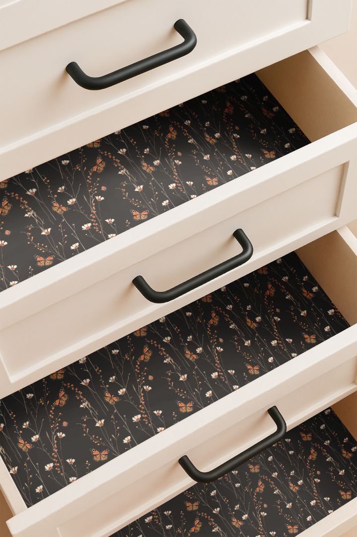 Drawer lined with monarch butterfly and wildflower contact paper on deep black background