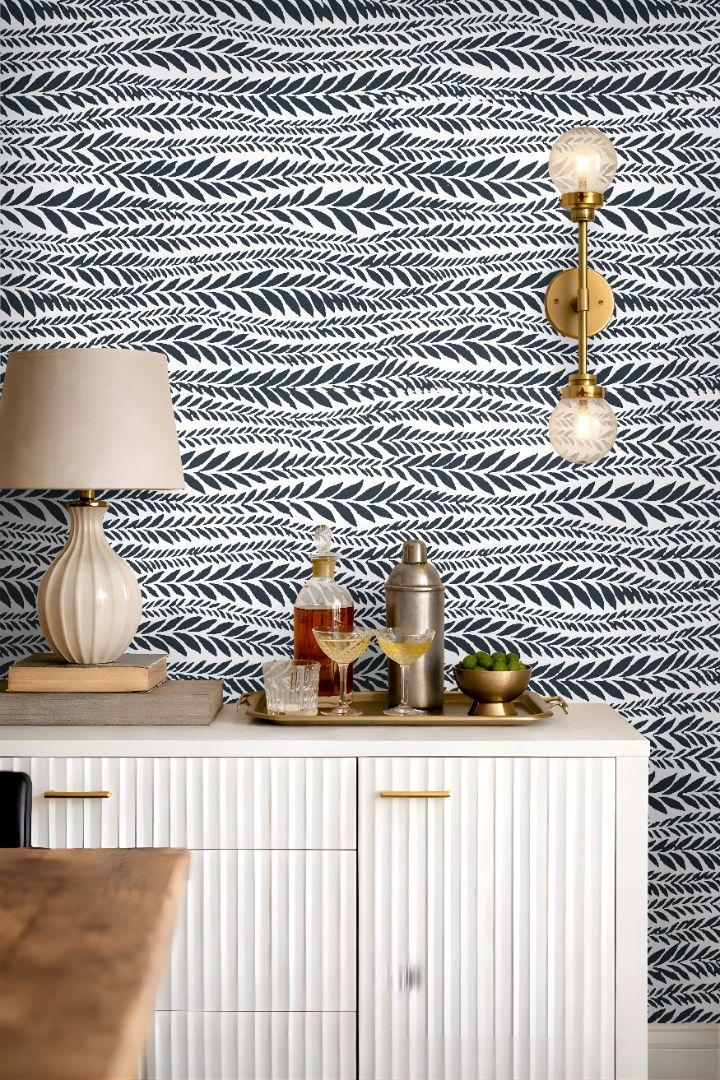 laurel row blue botanical wallpaper styled behind bar cabinet with brass accents