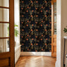 Maple Noir wallpaper accent wall with golden branches and florals in warm sunlight