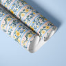 Marigold Manor Peel and Stick Contact Paper rolls styled on blue background with luxury floral stripe design