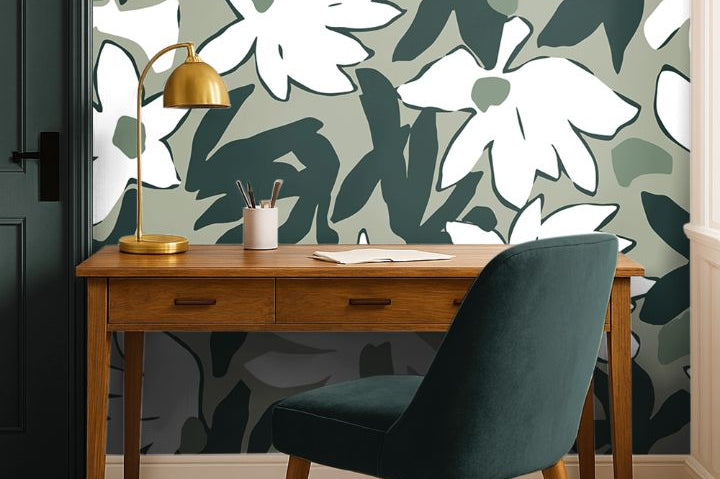 Mosselle Bloom Wallpaper styled behind wooden desk and brass lamp, showing organic olive and ivory tones