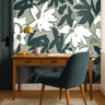 Mosselle Bloom Wallpaper styled behind wooden desk and brass lamp, showing organic olive and ivory tones