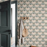  blue green floral wallpaper in entryway with dark door wood hooks neutral coat and woven bag
