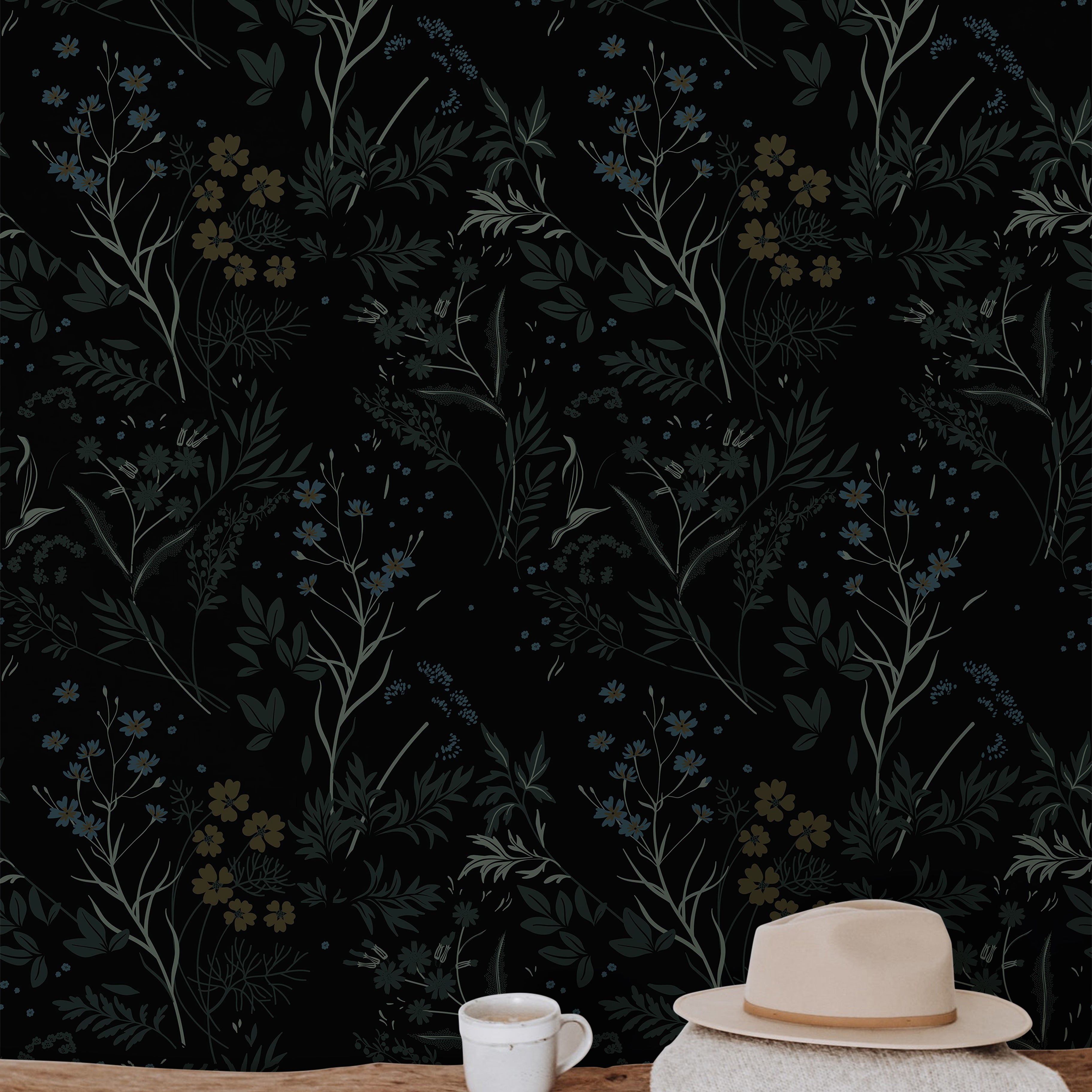 Moody botanical wallpaper featuring black floral wallpaper, muted blue wildflowers, earthy olive foliage, warm wood textures, and dark organic interior styling inspiration.