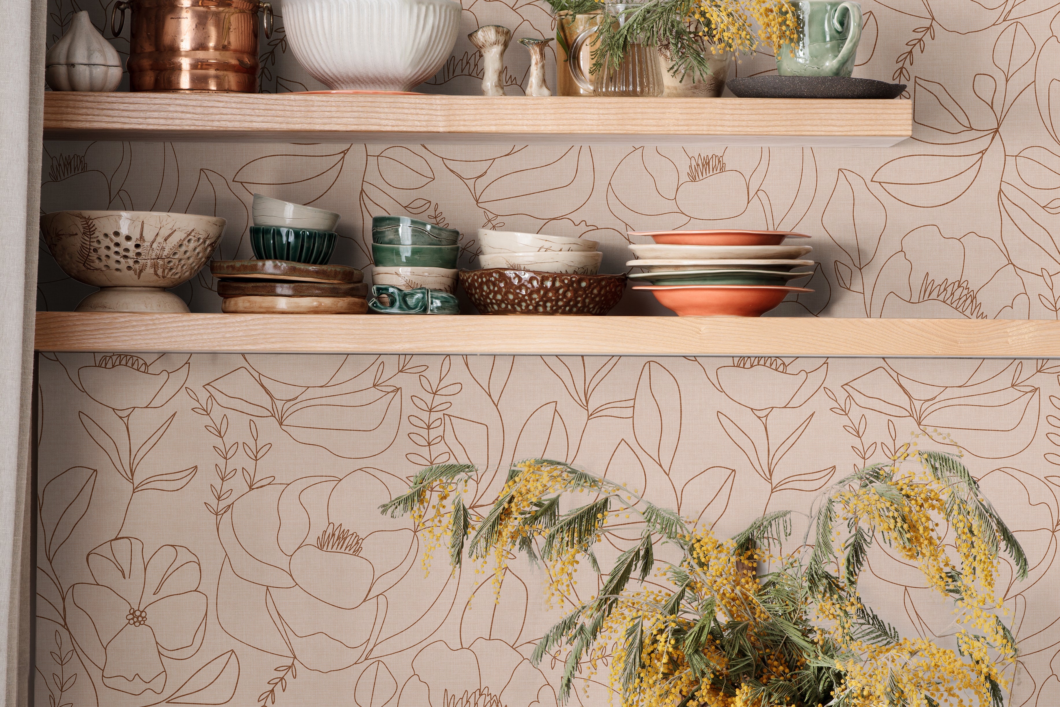 Open Bloom blush floral wallpaper with botanical line art in a warm kitchen with open wood shelving and green cabinets