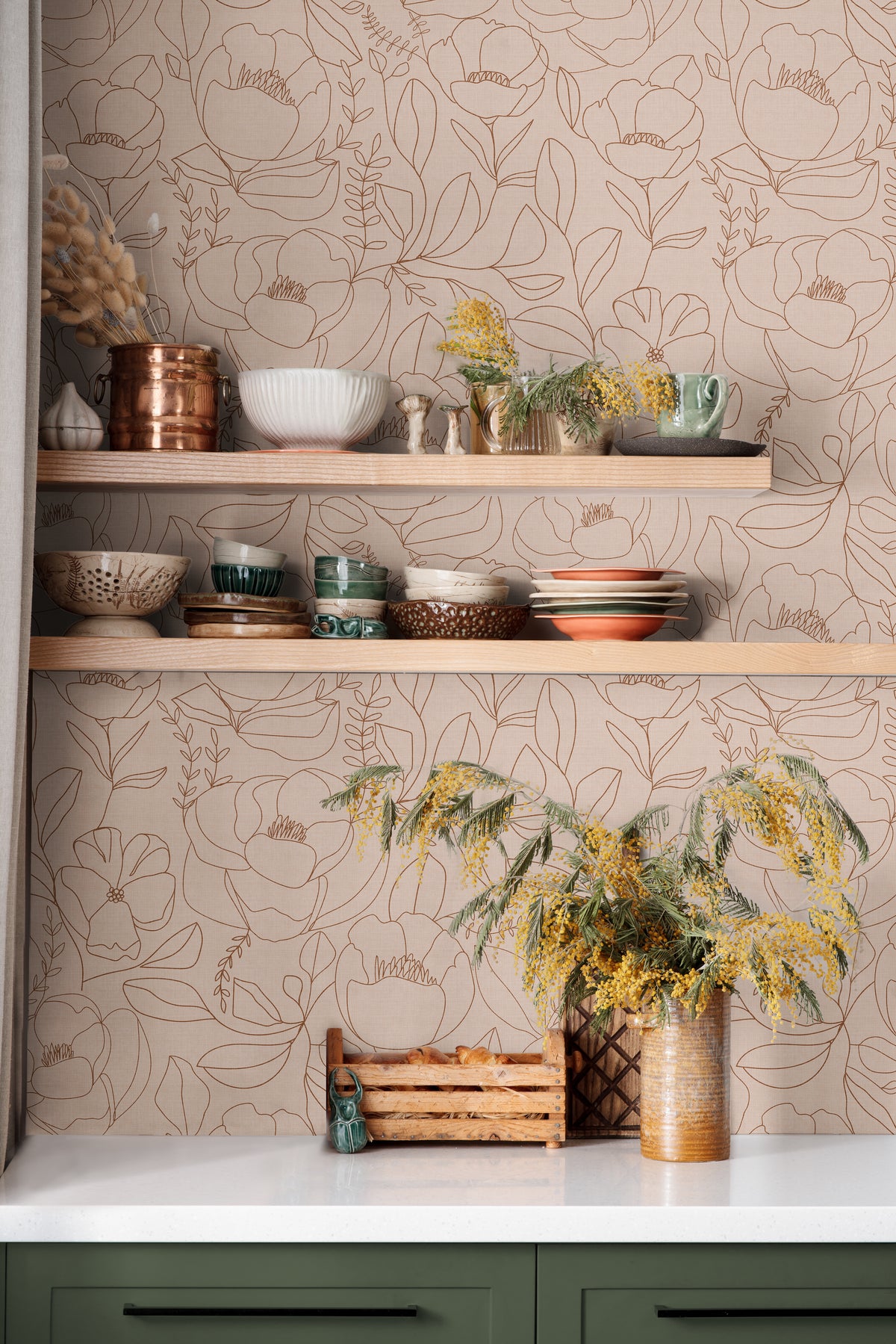 Open Bloom blush floral wallpaper with botanical line art in a warm kitchen with open wood shelving and green cabinets