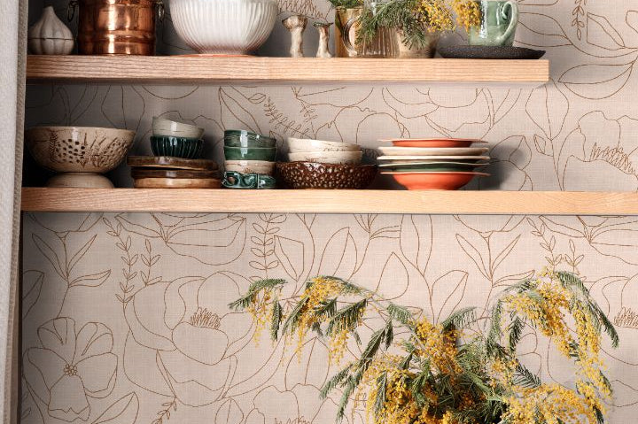 Line-drawn floral wallpaper in warm beige and clay tones styled in a kitchen shelving space