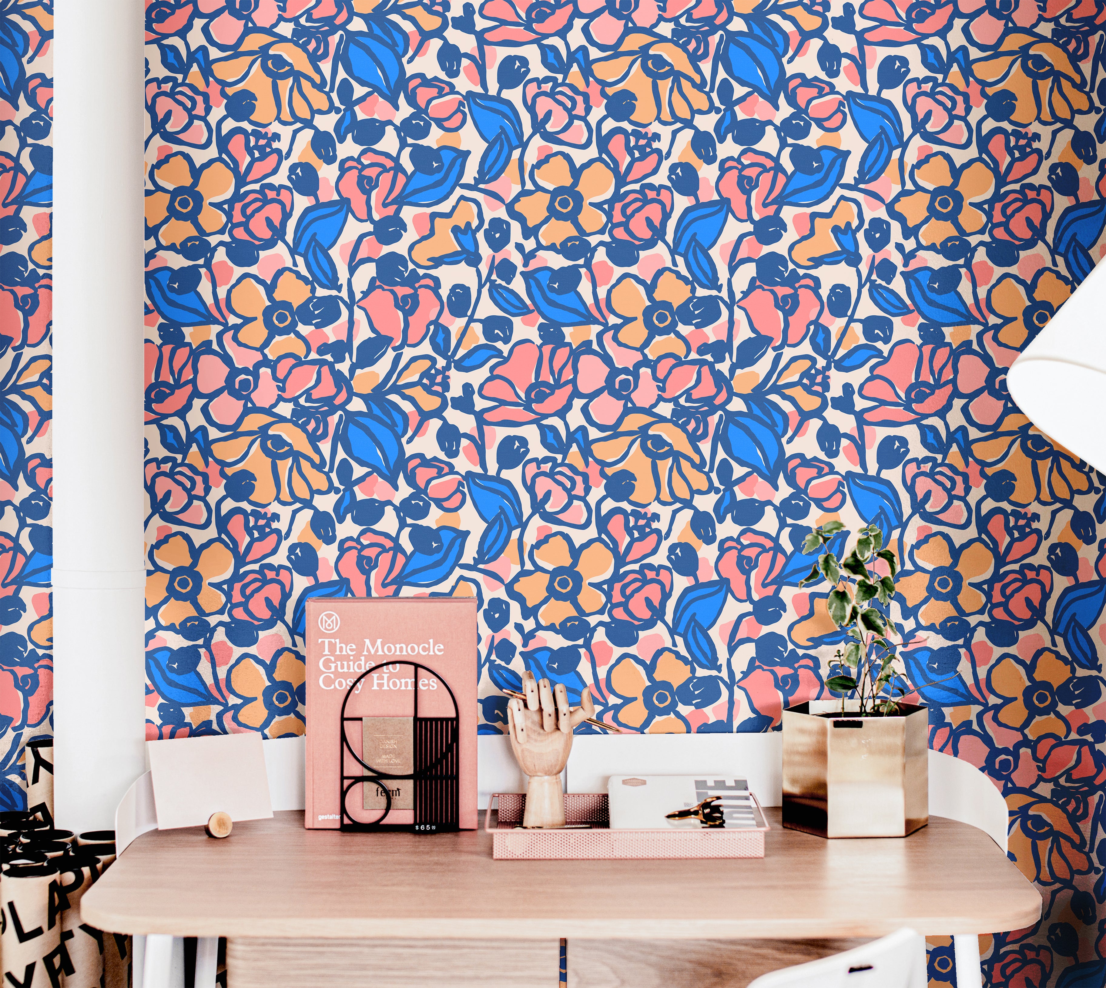 Colorful floral wallpaper with cobalt blue and blush peach flowers in a playful teen bedroom with pink decor and modern styling.