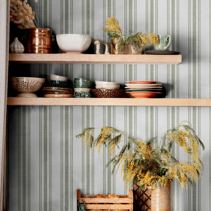 Sage Lineage wallpaper in kitchen with green and white stripes behind open shelving and ceramics