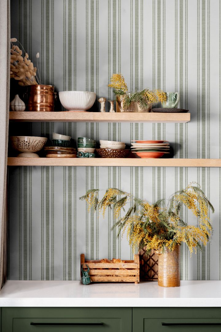 Sage Lineage wallpaper in kitchen with green and white stripes behind open shelving and ceramics