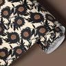 Roll view of Santal Bloom peel and stick contact paper featuring oversized ivory floral blooms with black linework and terracotta accents.