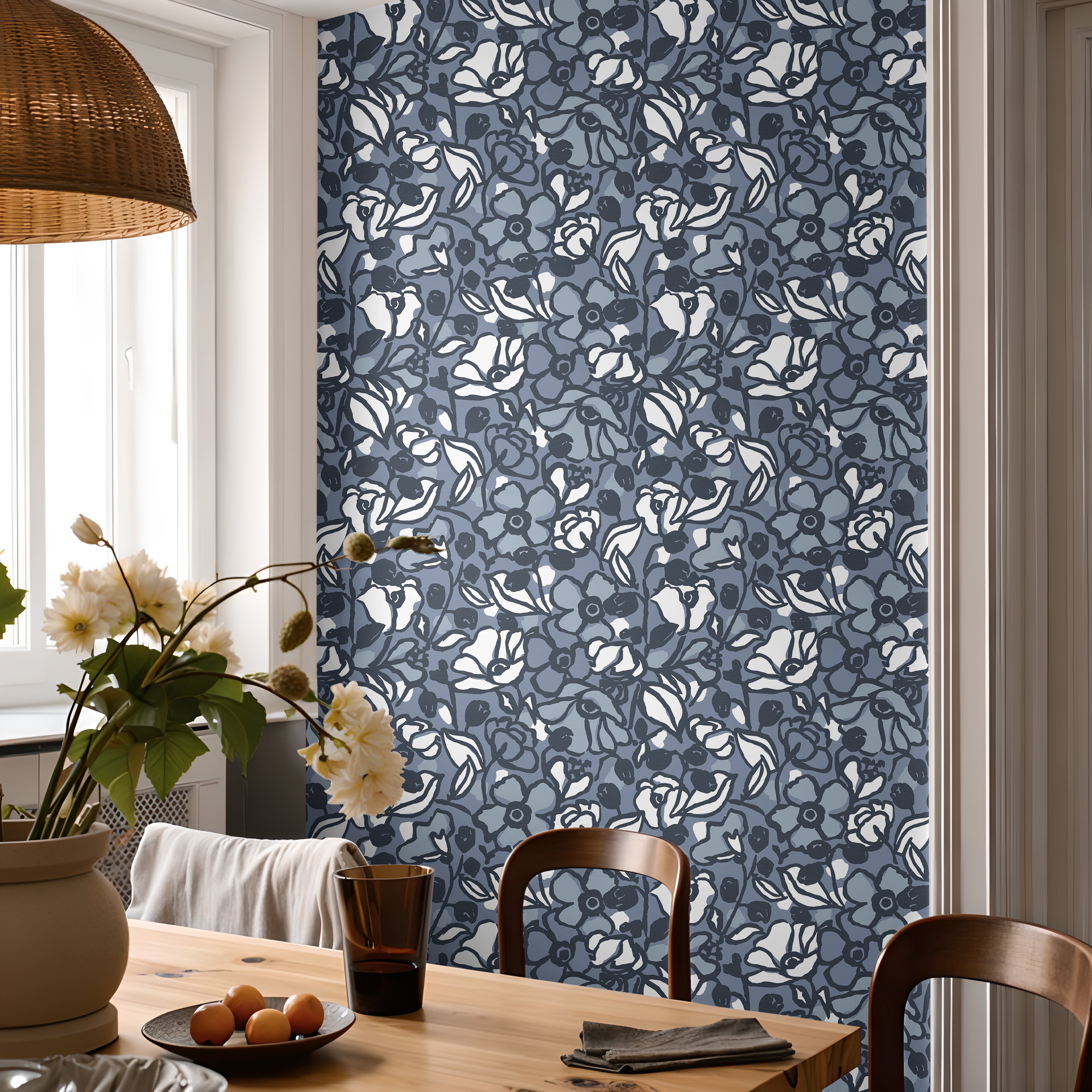 Blue floral wallpaper with layered hand drawn flowers styled in a bright dining room.