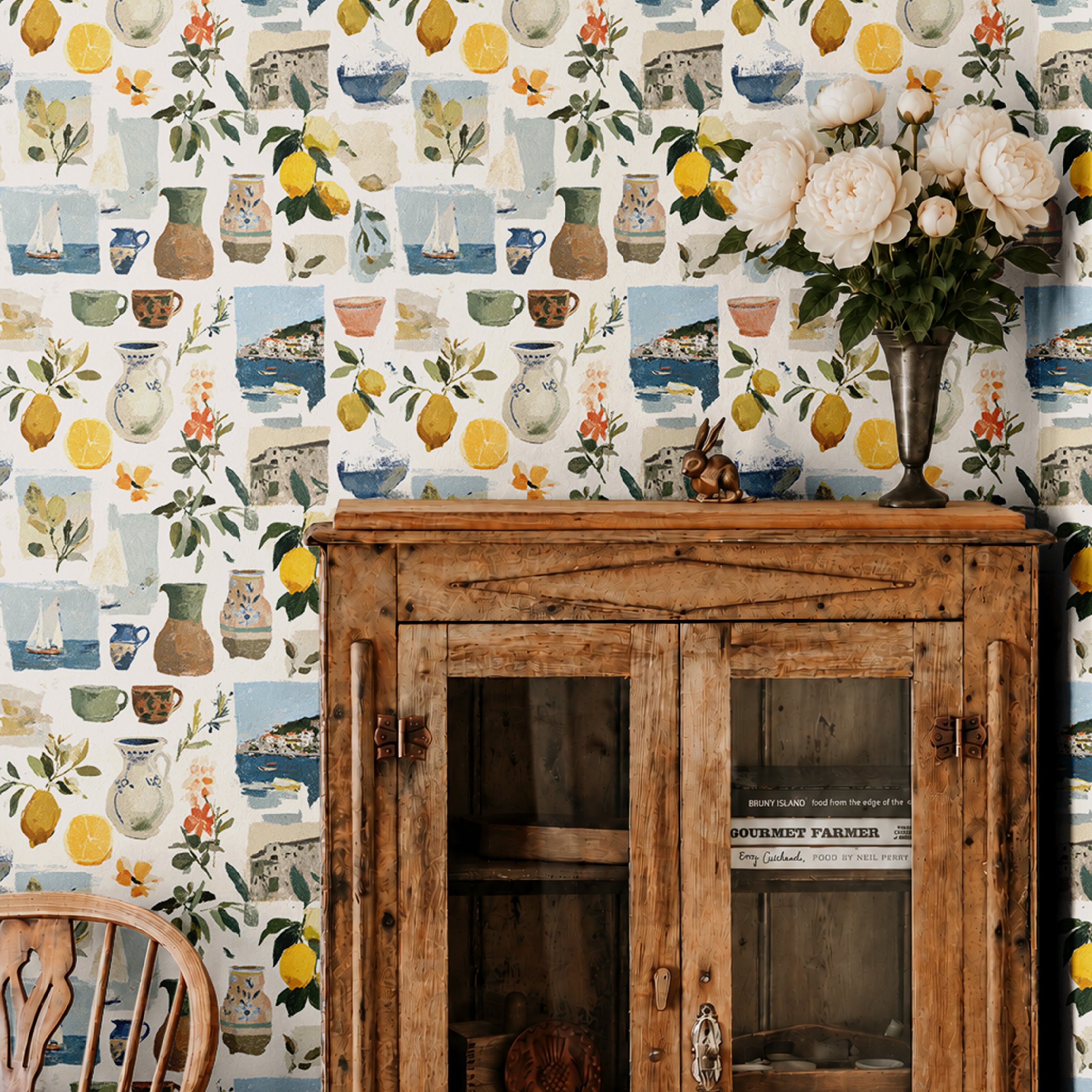 Sorella Coast 3143 Italian coastal wallpaper with watercolor lemons, Mediterranean pottery, sailboats and seaside scenes styled with a vintage wood cabinet