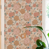blush and peach floral wallpaper in living corner, with small marble table with stacks of books and wall decor