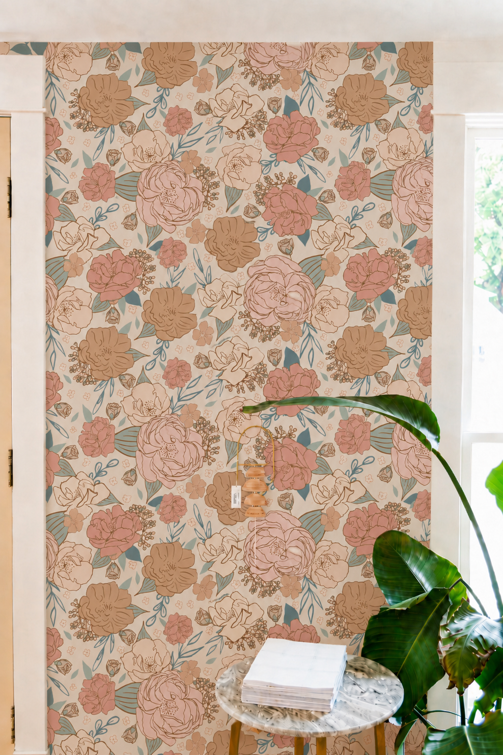 blush and peach floral wallpaper in living corner, with small marble table with stacks of books and wall decor