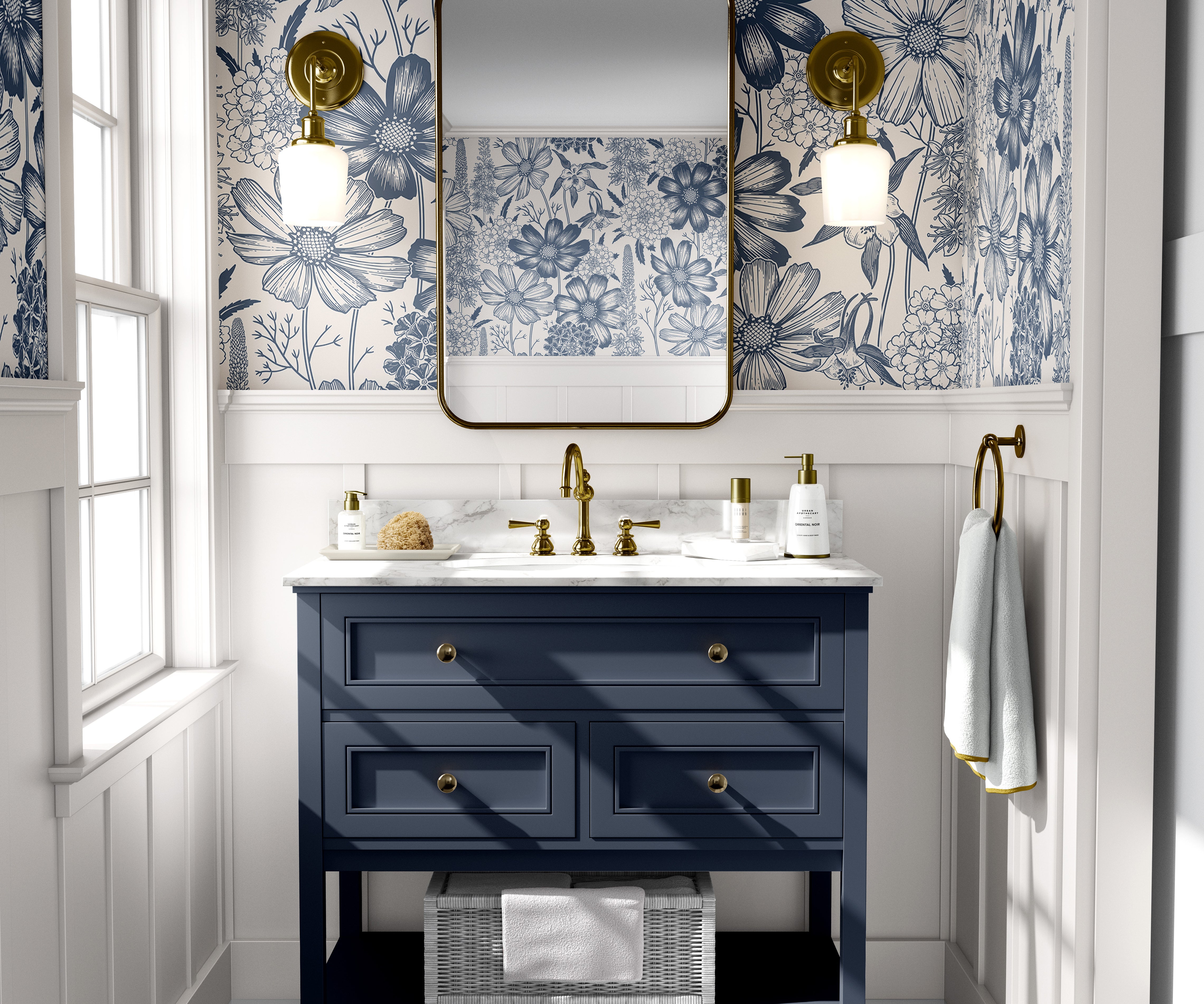 Blue floral toile wallpaper styled in a bright bathroom with a navy vanity, brass fixtures, and marble countertop.