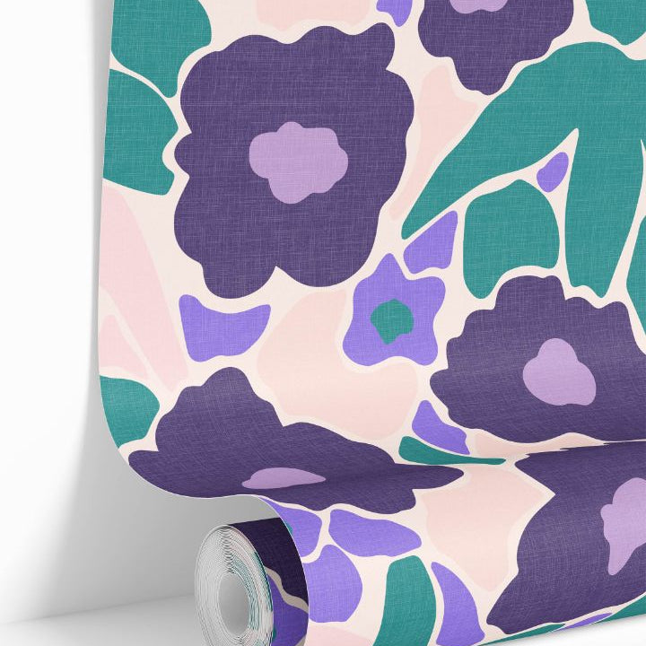 Violetta Bloom Wallpaper roll featuring painterly violet, lilac, and teal florals on a blush background.