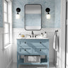 Blue coastal wallpaper with flowing wave patterns styled in a bright modern bathroom with soft coastal decor.