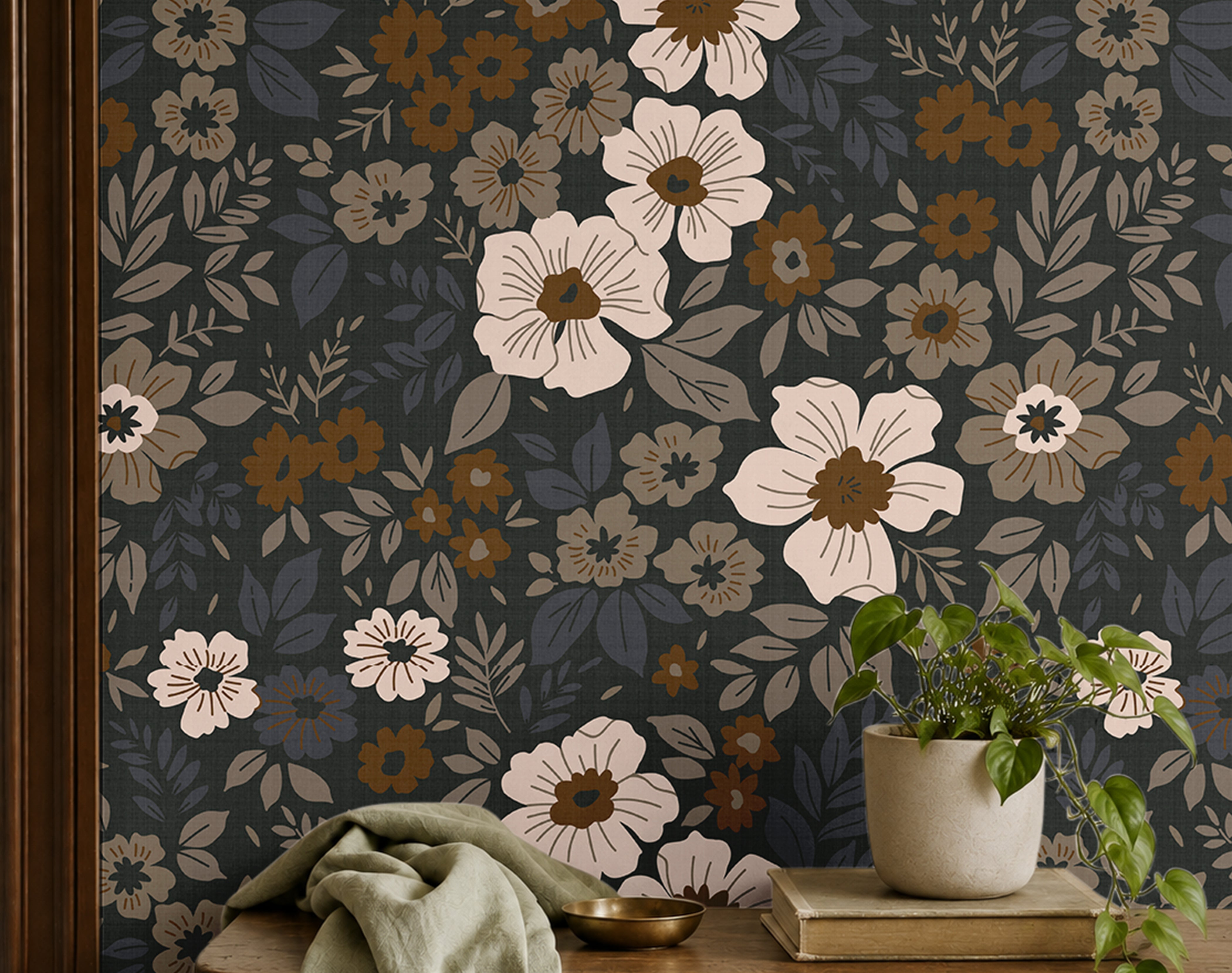 dark floral wallpaper with cream and amber flowers behind a wood bench with sage fabric and a potted plant
