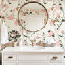 bathroom with blush floral wallpaper, butterflies and songbirds, round brass mirror