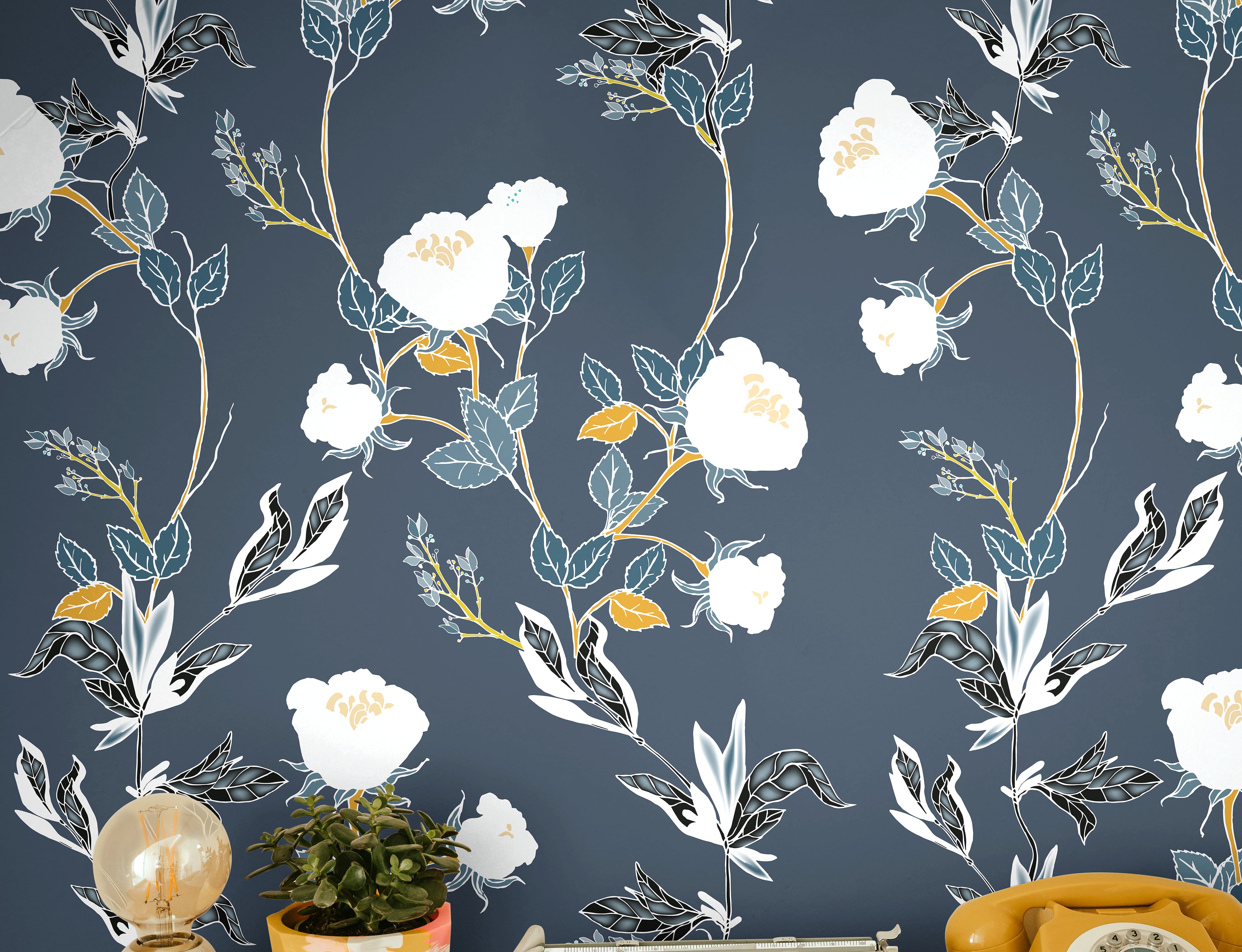 white florals with green and orange stems on lighter navy background behind eclectic desk interior