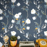 white florals with green and orange stems on lighter navy background behind eclectic desk interior