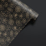Roll of Wild Noir dark floral contact paper with black and gold botanical sketch pattern.
