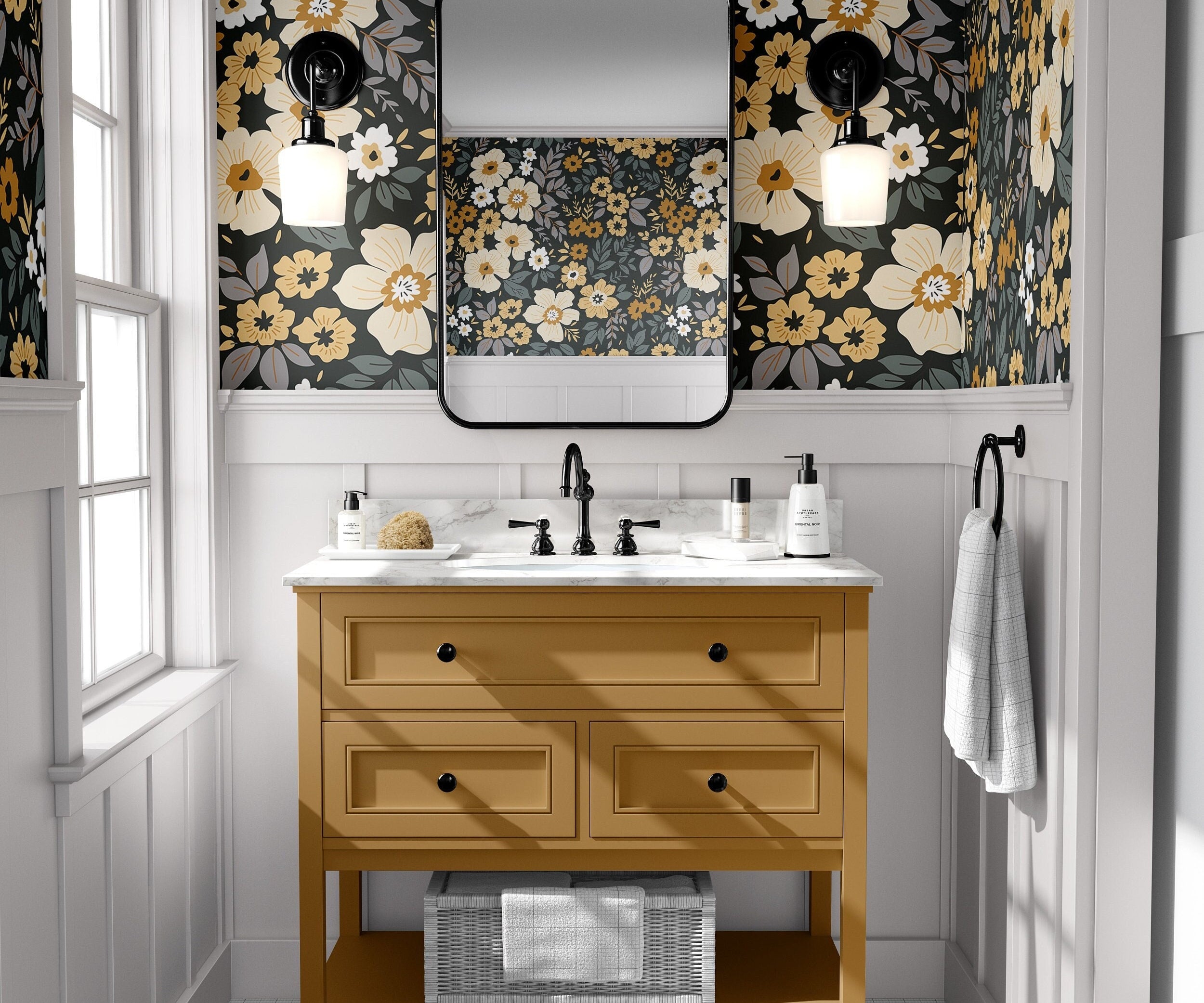 charcoal floral wallpaper in powder room with mustard vanity black framed mirror black sconces and white paneling