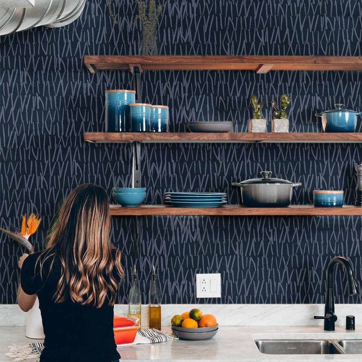 Navy blue abstract line wallpaper behind kitchen open shelving