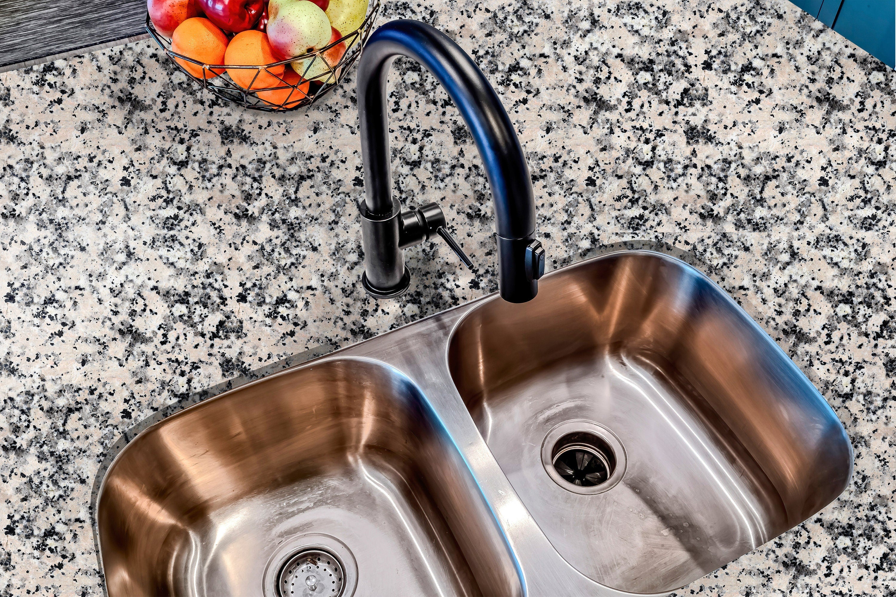 Countertop 17: Close-up of speckled granite peel-and-stick vinyl paper applied to a kitchen countertop, featuring a realistic beige and black stone design with a waterproof finish.