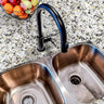 Countertop 16: A modern kitchen countertop covered in white granite-patterned film with gold and black speckles, offering a luxurious and elegant stone look.