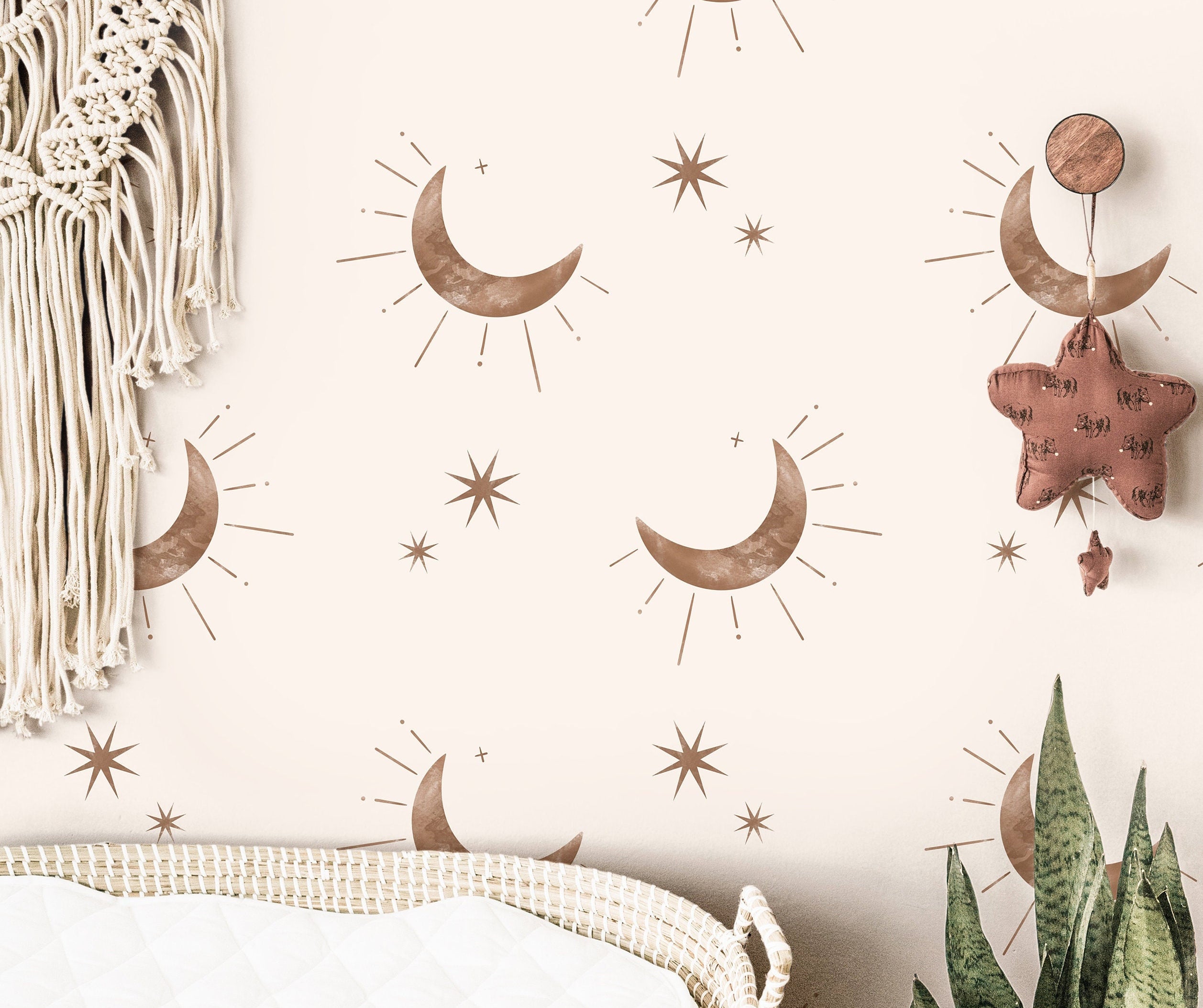 Wallpaper 3844: Neutral boho nursery wallpaper featuring soft brown crescent moons and minimalist starbursts on a cream background, styled above a woven changing basket with natural accents.