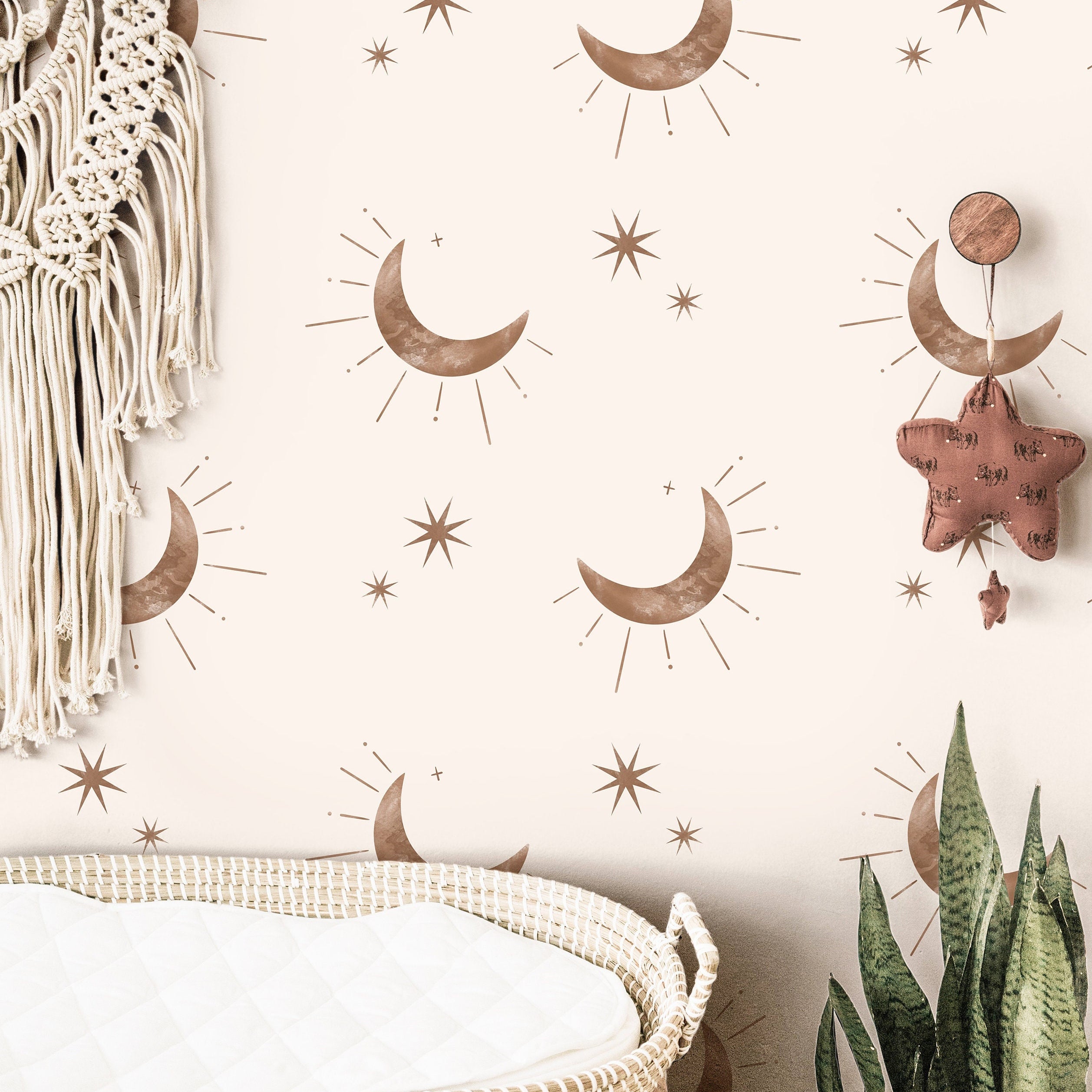 Wallpaper 3844: Neutral boho nursery wallpaper featuring soft brown crescent moons and minimalist starbursts on a cream background, styled above a woven changing basket with natural accents.
