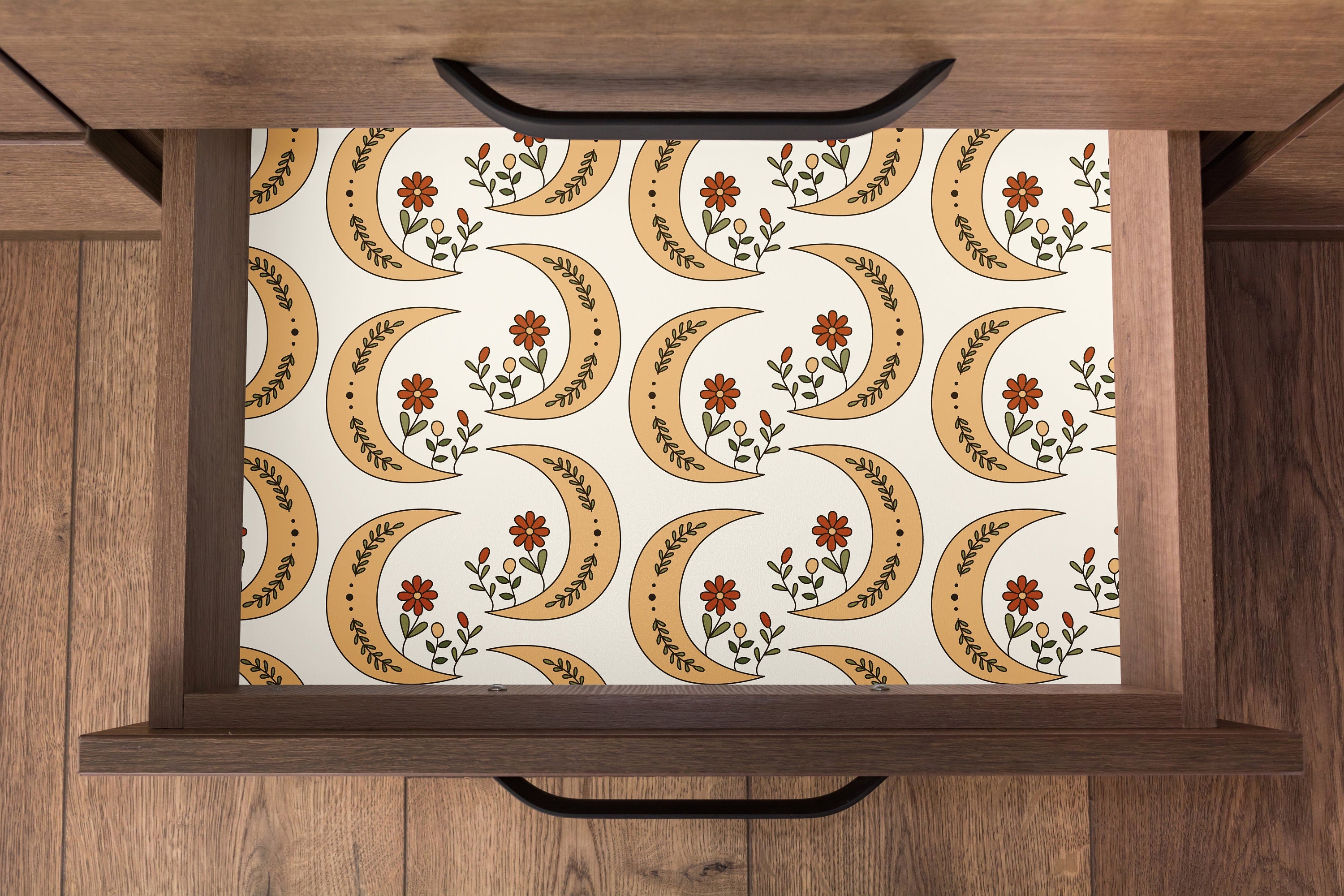Contact Paper 1555: Drawer lined with contact paper featuring repeating crescent moons in golden ochre tones, decorated with red flowers and green foliage on a creamy background in a boho celestial style.