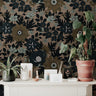 Wallpaper 919: Wallpaper featuring oversized black and olive floral motifs with pale green accents on a rich taupe background, styled with a cream console, terracotta potted plant, and earthy tabletop decor.