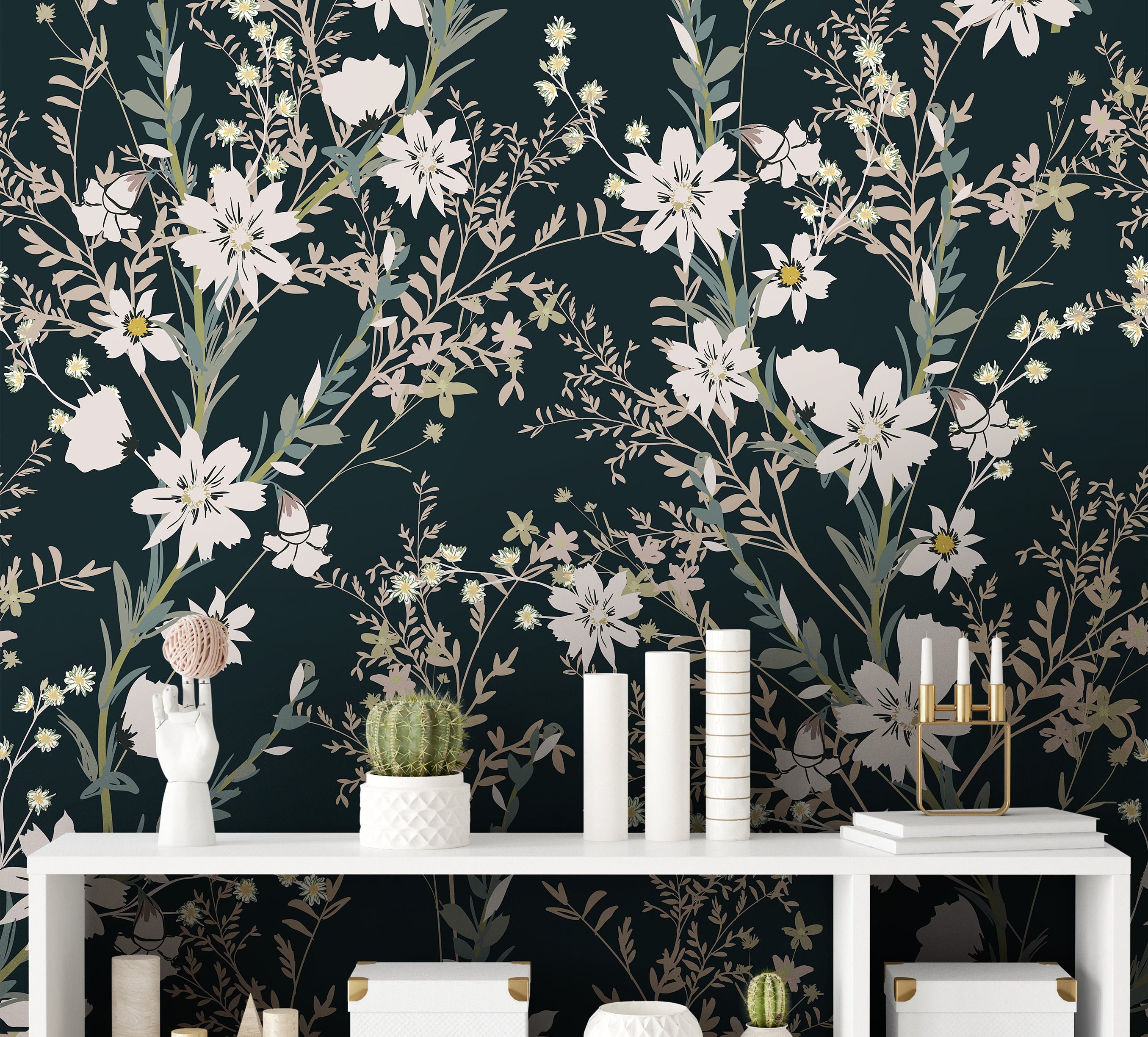 Wallpaper 898: A stylish dark green wallpaper adorned with cream and sage-toned wildflowers and delicate leaves, arranged in a sophisticated, large-scale botanical pattern behind a modern white shelving unit with decorative accents.