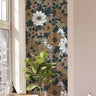 Wallpaper 783: Earth-toned floral wallpaper featuring white, mustard, and tan blooms with dark green foliage in a cozy reading nook with natural sunlight and indoor plants.

