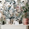 Wallpaper 918: A cozy and neutral-toned wallpaper featuring a detailed botanical print with warm earthy florals and foliage in mustard, cream, and terracotta hues, styled behind a dresser with plants and ceramics.