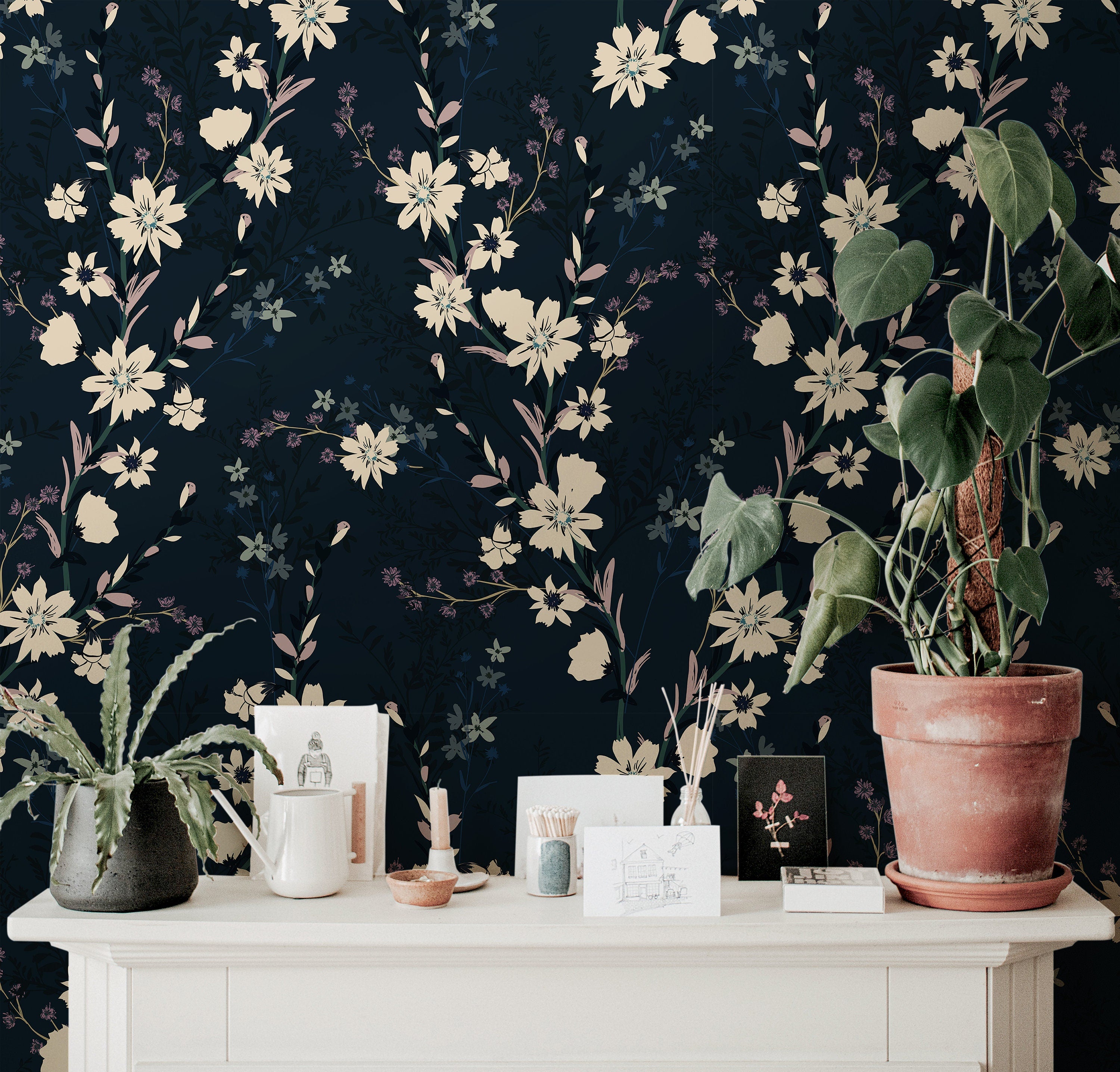 Wallpaper 916: Wallpaper with cream and blush florals blooming against a rich navy-black background, styled behind a white console with potted plants and delicate decor.