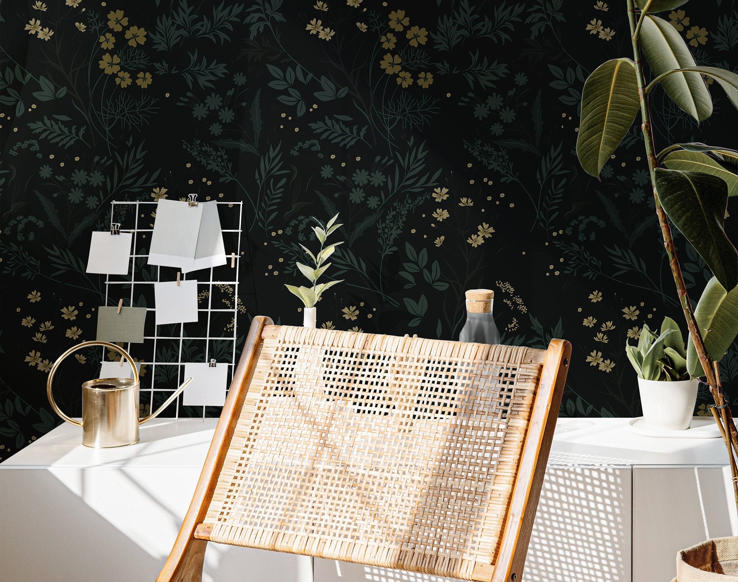 Wallpaper 863: Dark floral wallpaper featuring delicate yellow and green botanicals on a deep black background, styled with a woven lounge chair, modern decor, and indoor plants in natural light.
