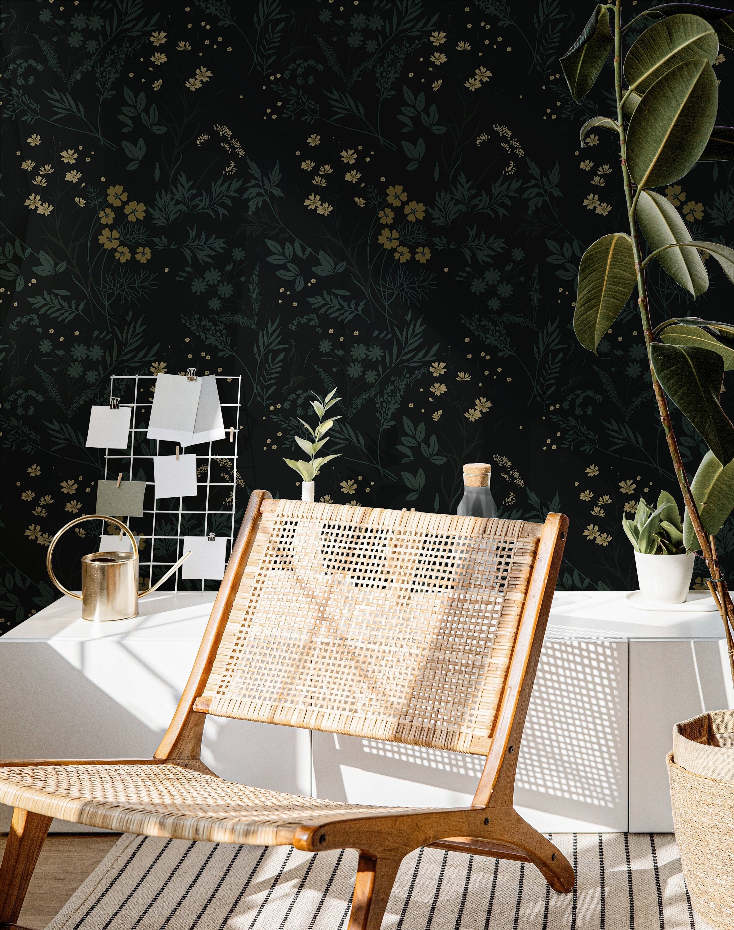 Wallpaper 863: Dark floral wallpaper featuring delicate yellow and green botanicals on a deep black background, styled with a woven lounge chair, modern decor, and indoor plants in natural light.