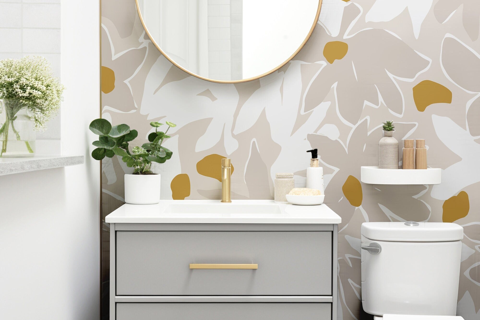 Wallpaper 1138a: Modern bathroom with abstract beige and mustard floral wallpaper, featuring a light gray vanity and round gold-framed mirror.