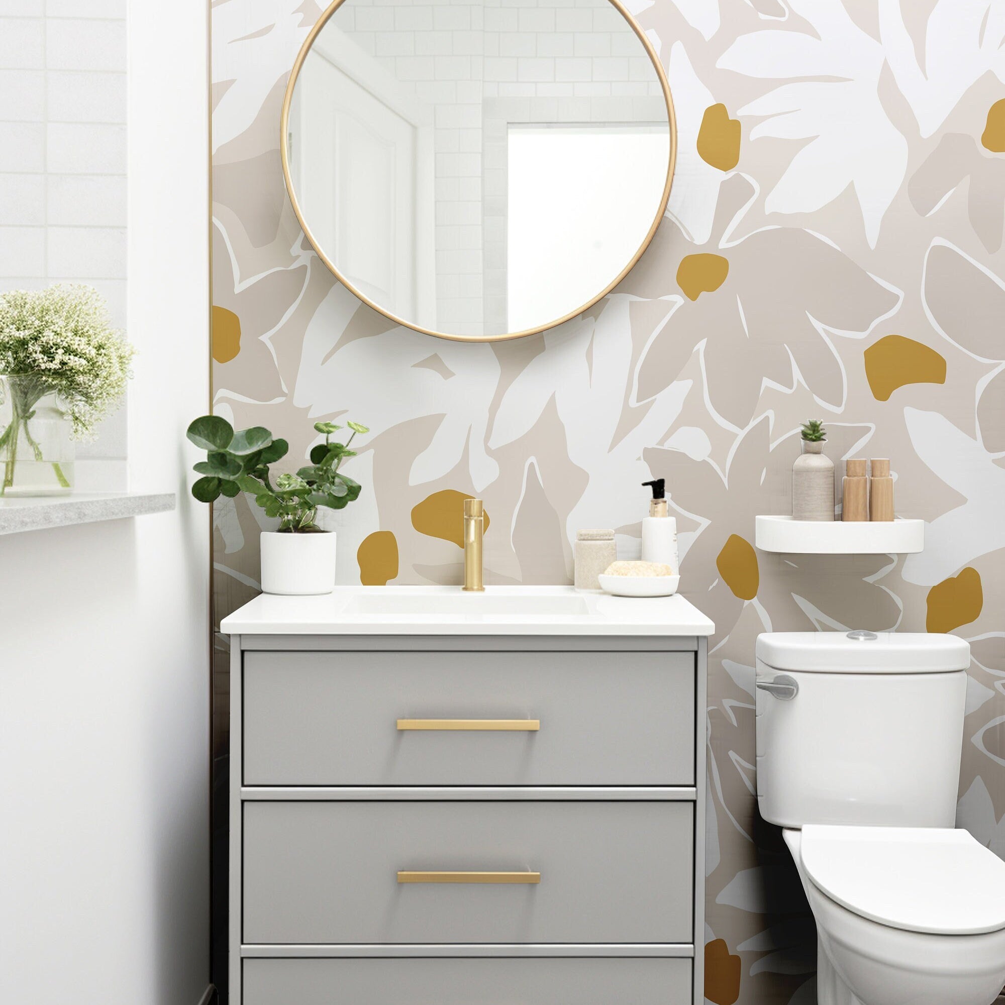 Wallpaper 1138a: Modern bathroom with abstract beige and mustard floral wallpaper, featuring a light gray vanity and round gold-framed mirror.