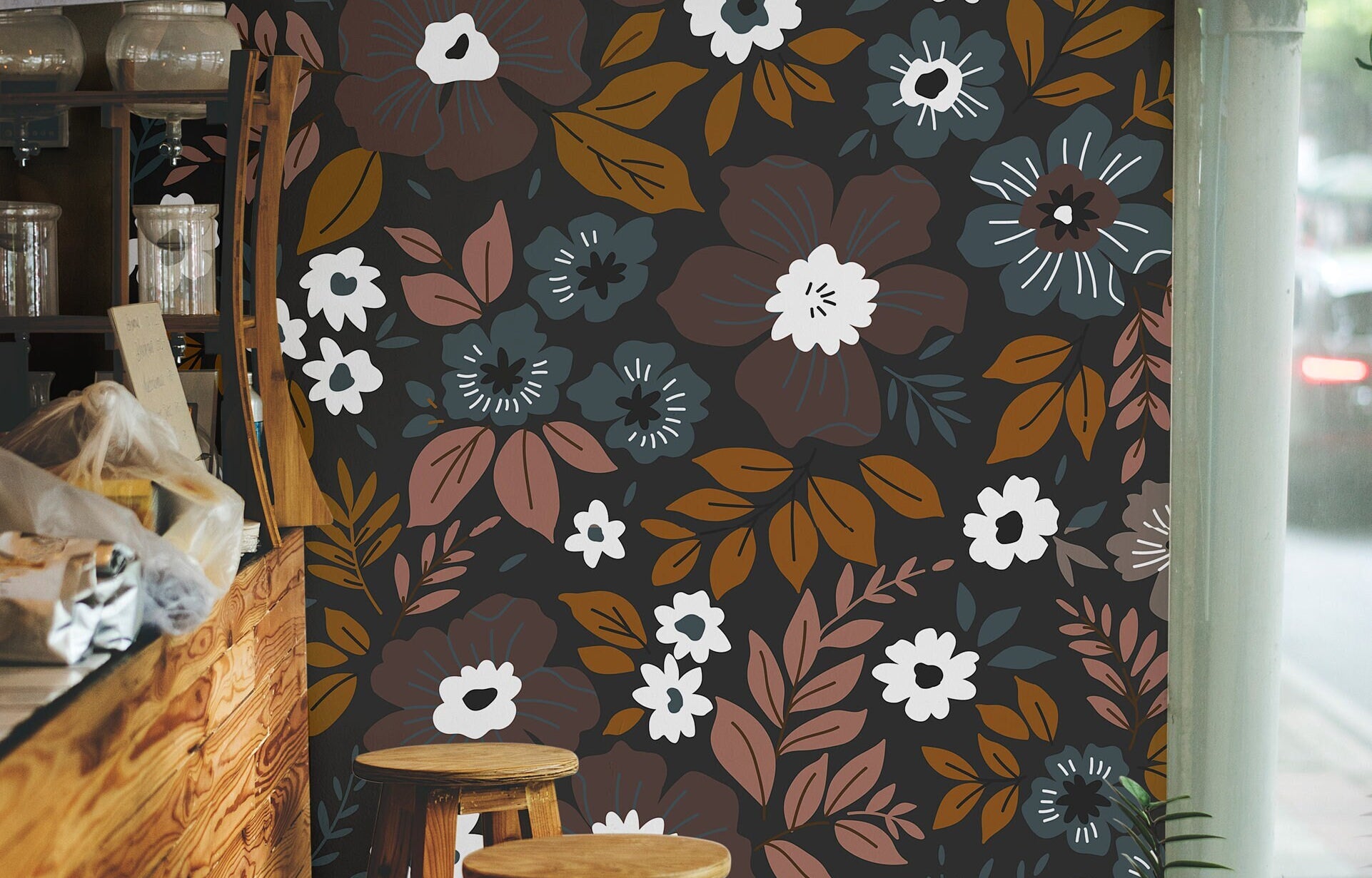 Wallpaper 1060a: Retro floral wallpaper with white, amber, rust, and dusty blue flowers against a dark background in a cozy café interior.