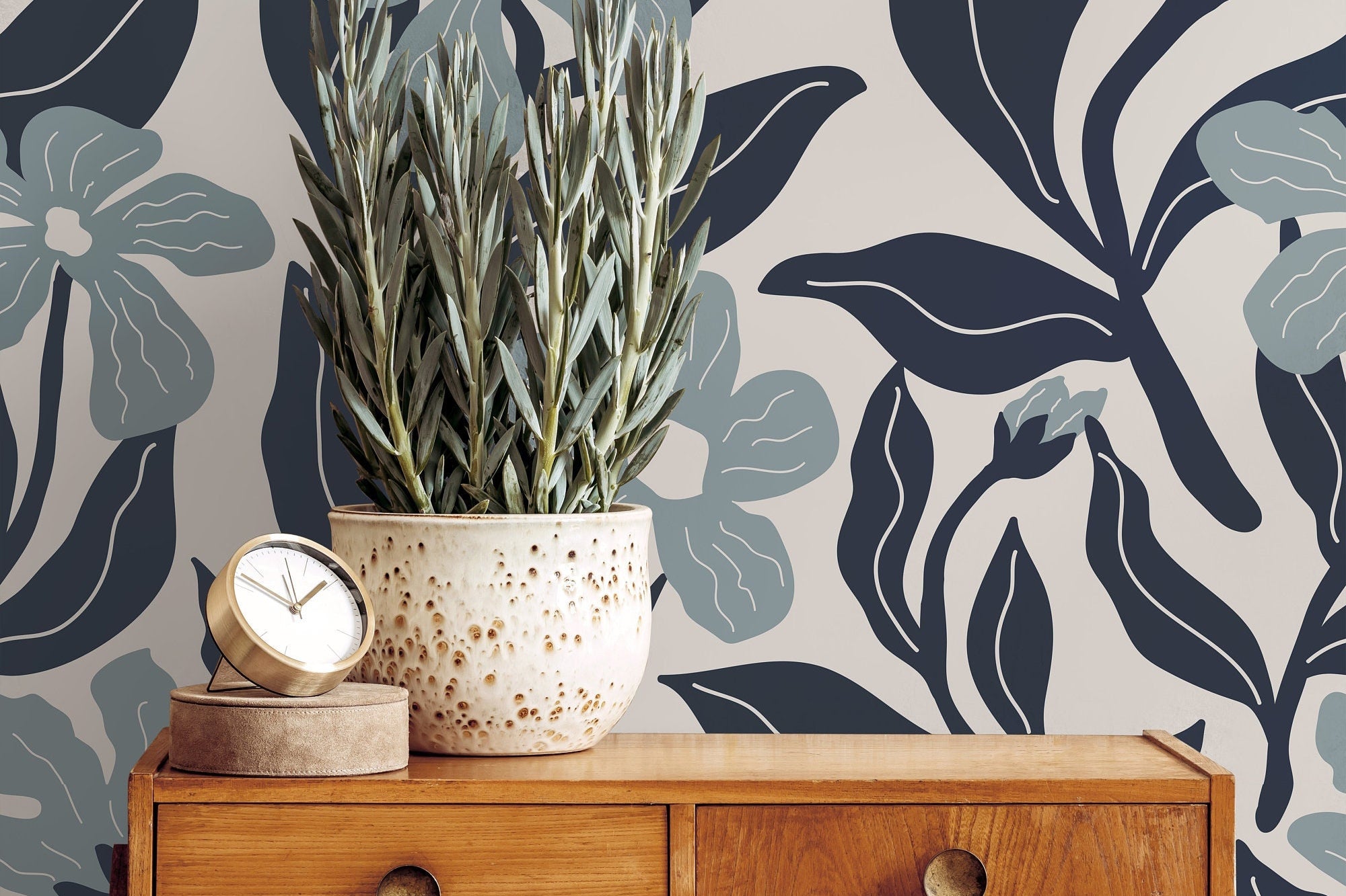 Wallpaper 1133: A close-up view of a modern floral wallpaper featuring oversized blue and gray flowers with elegant dark leaves, set against a beige background, creating a sophisticated and bold statement wall.